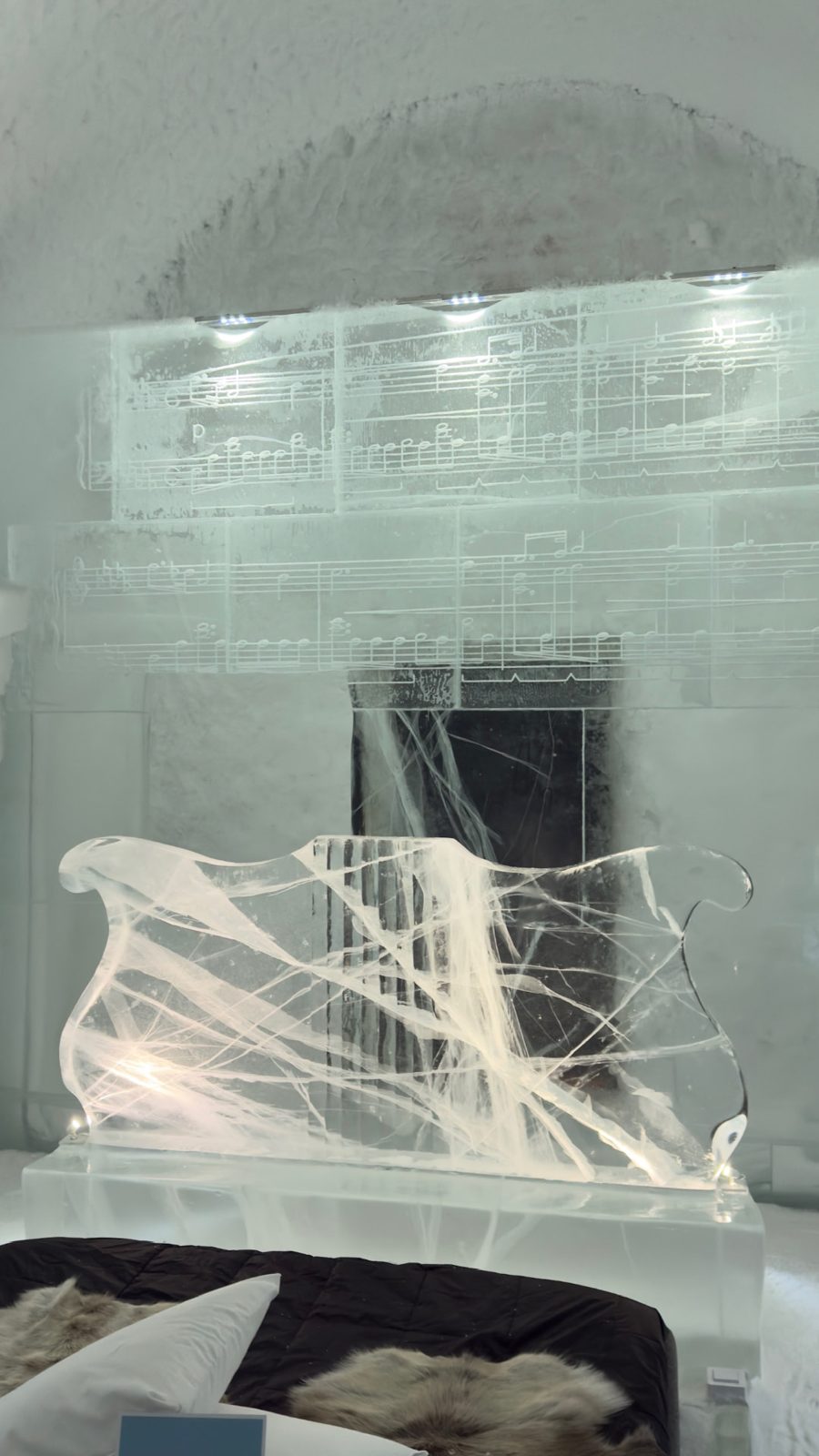 Suíte de arte do Icehotel com partitura musical esculpida em uma parede de gelo.